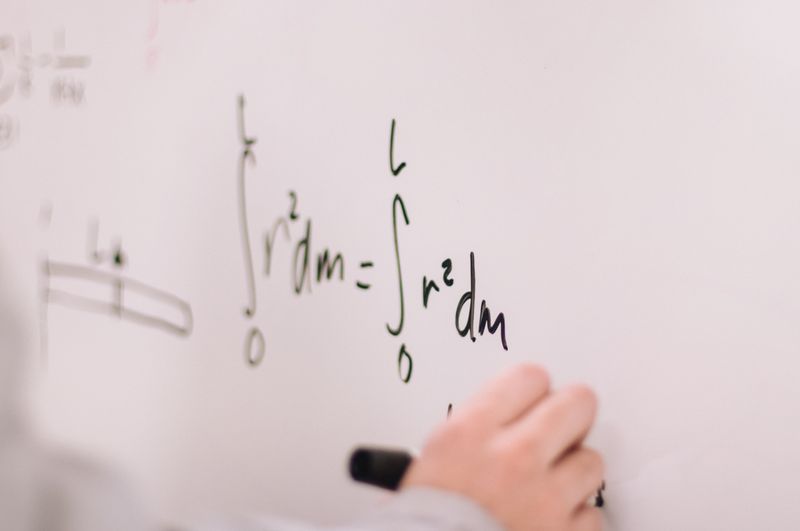 Math formula is written on a whiteboard.