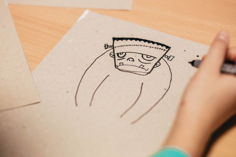 Person doodling Frankenstein on a paper