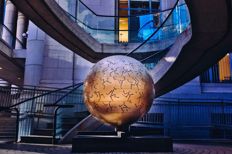 A globe statue in the lobby of a modern business tower.
