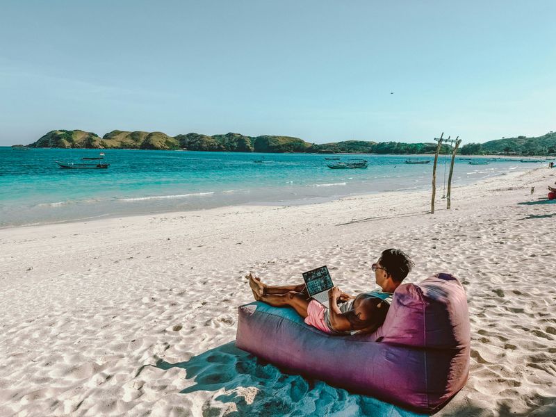 Man sitting on a couch at the beach. 