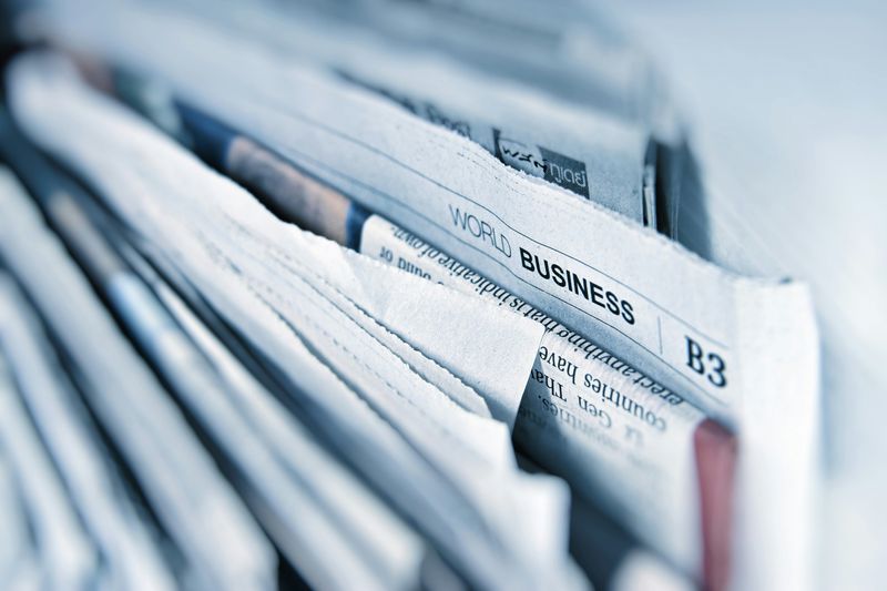 A collection of newspapers showing World Business as a heading.