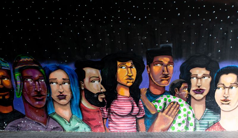A mural image of people from diverse backgrounds under a night sky.
