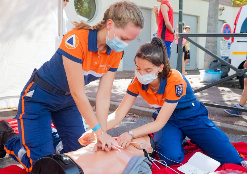 Paramedics performing life saving procedures on a dummy.