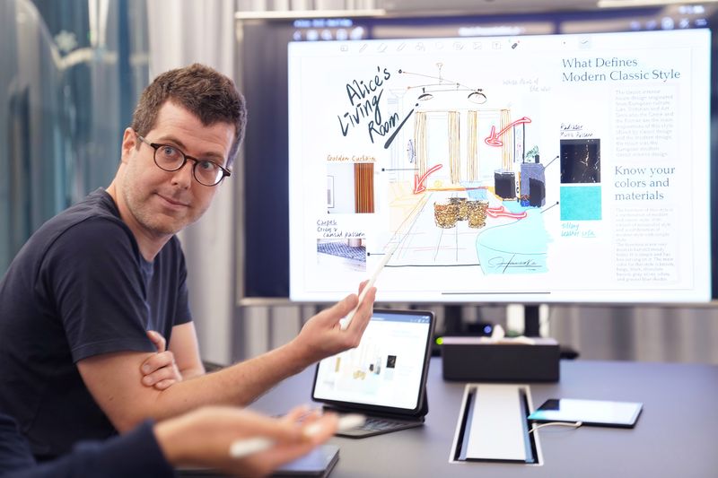 man presenting information on a screen in a classroom