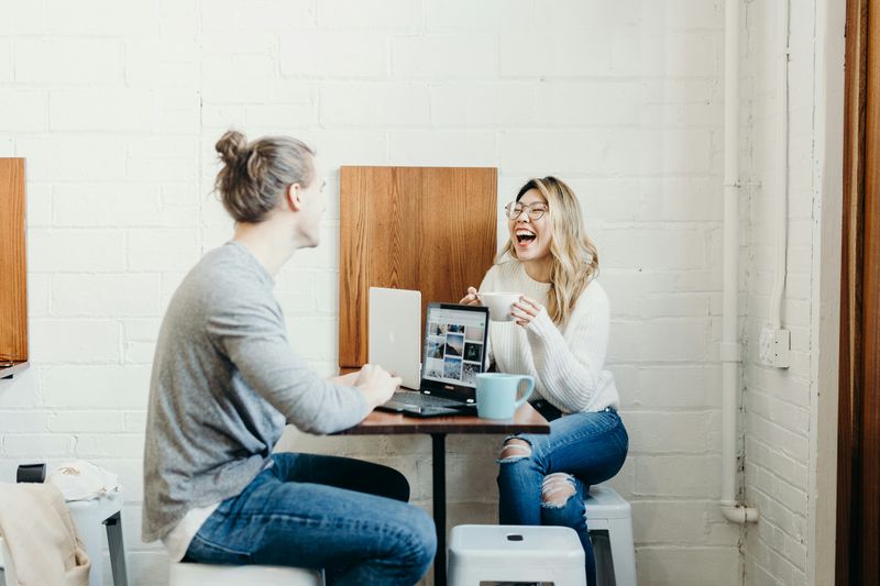 People having a conversation and laughing while having coffee