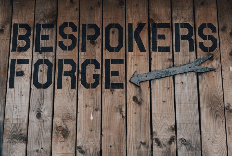 Shop named, 'Bespokers Forge' written on the outside of a wooden structure.