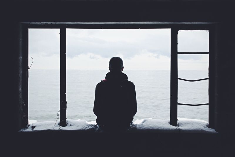 person sitting alone near a window