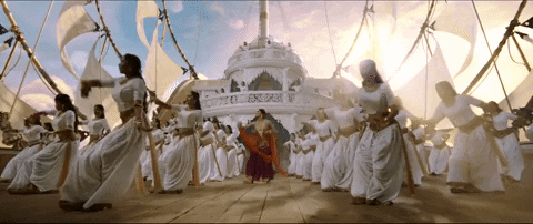A Bollywood dance scene in front of a white palace