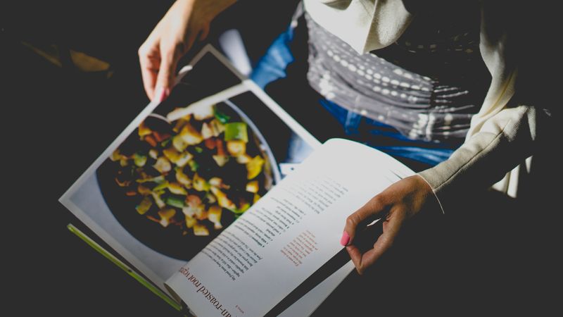 Person looking at recipe in cookbook