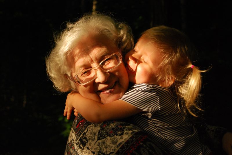Old woman hugging young girl 