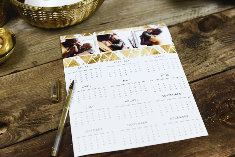 A year calendar on a wooden table with a pen on the left side.