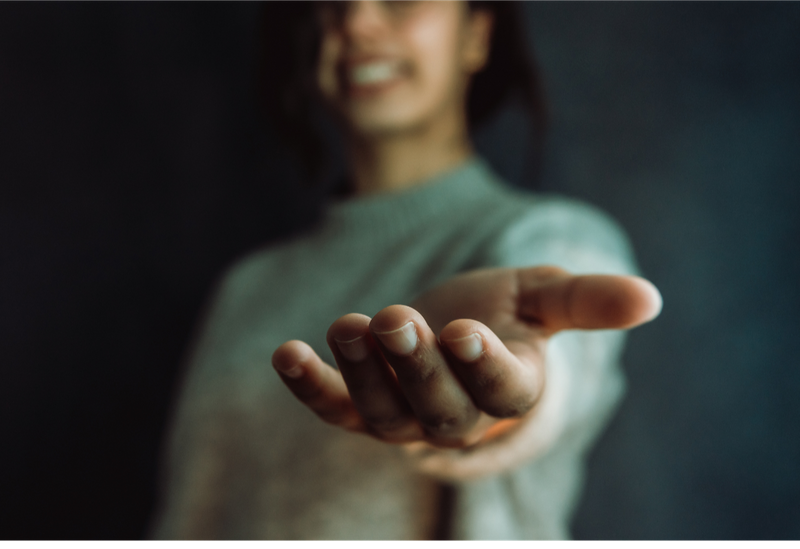 A woman with hand extended. Image from Canva.