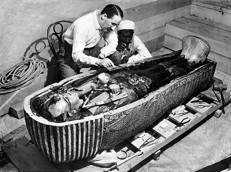 Two archaeologists looking at King Tut's open tomb.