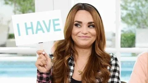 Woman holding up sign with the words - I have - on it. 