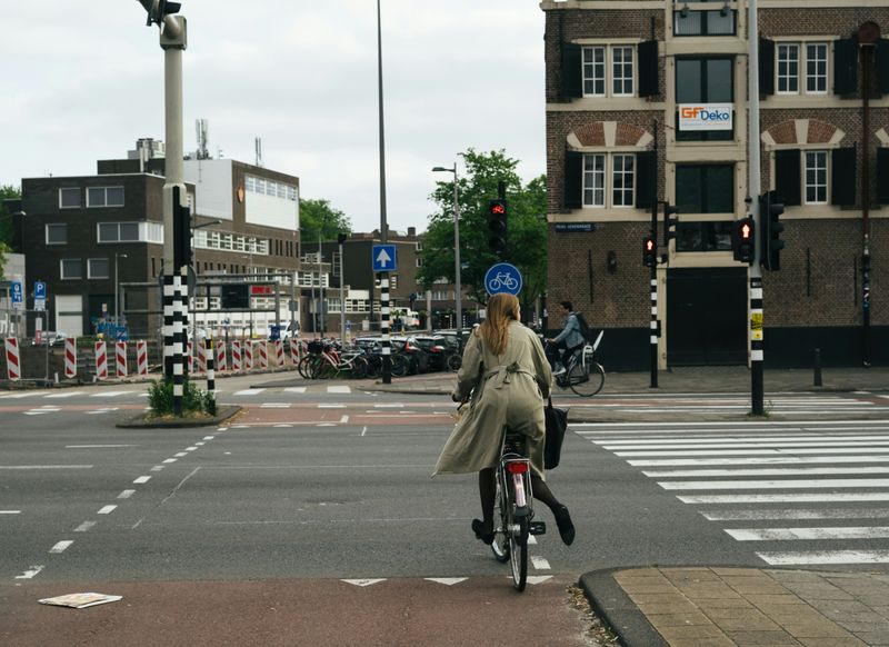 A person cycling, waiting for the green light.