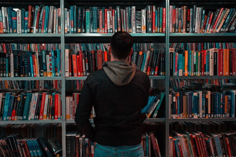 Man looking at a shelf of books