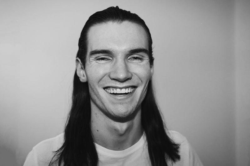 A person with long hair smiling.