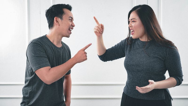 Two people arguing, pointing fingers at each other.