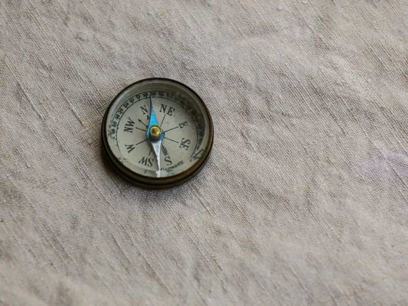 A compass resting on top of a fabric piece.