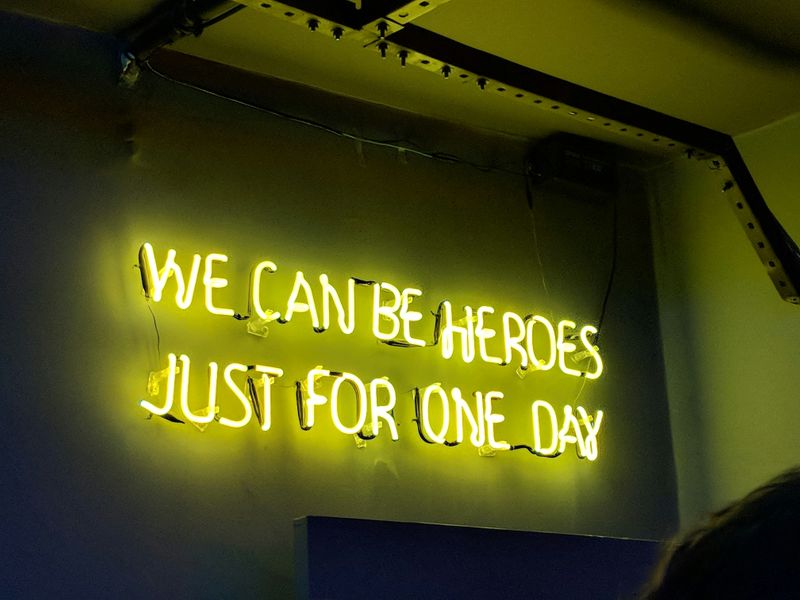 A wall sign in neon lights that reads, 