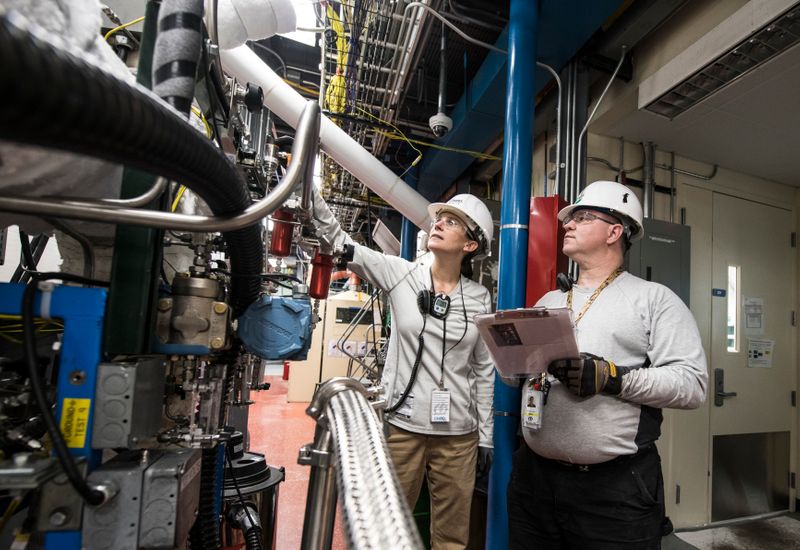 Two engineers inspecting factory equipment