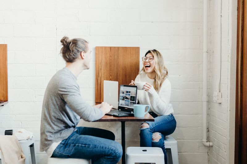 Two coworkers enjoying a coffee in a work break room.