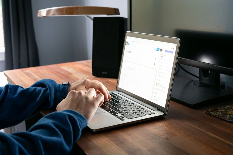 A man is typing on a laptop.