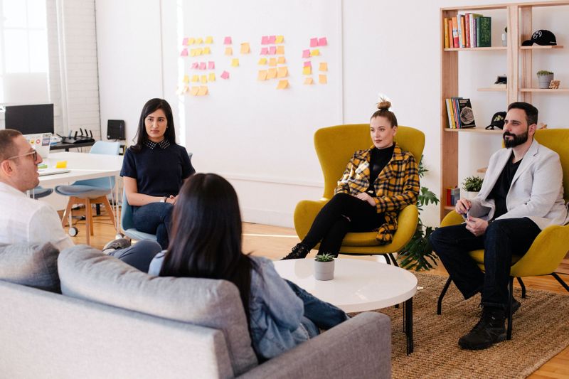 People sitting around a coffee table for meeting 