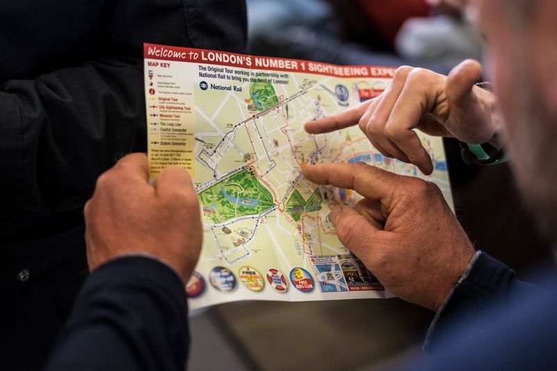 Two people pointing at a London sightseeing map.