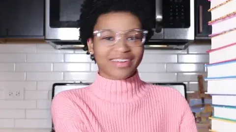 African American women moving a stack of books 