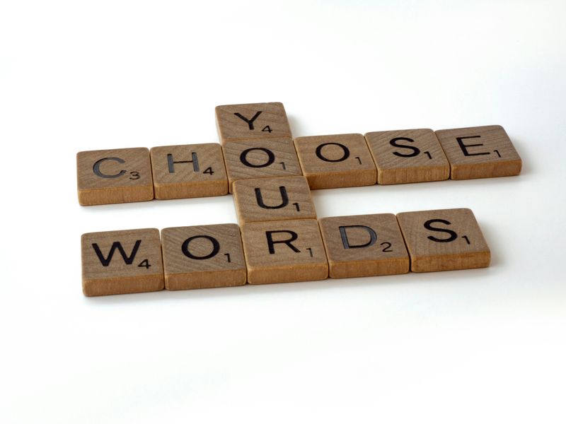 Some scrabble pieces are placed together to form the phrase, "Choose your words."