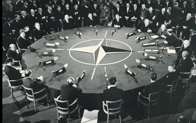 A group of leaders meeting at a huge roundtable at NATO headquarters.