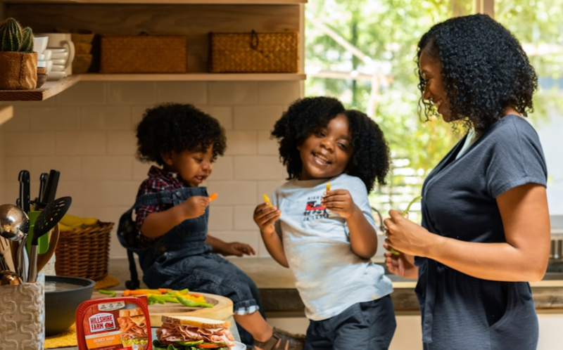 A mom and her two kids in the kitchen.