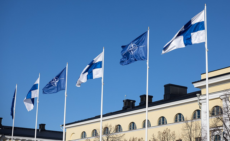 The Finnish and NATO flags flying over a building.