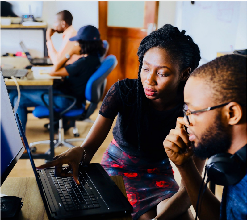 Two coworkers collaborate at a computer.