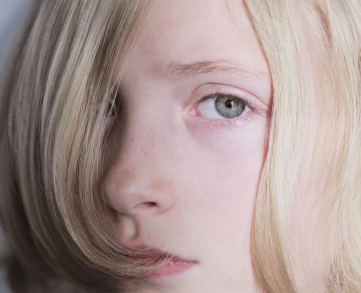 Face of a child with blond hair who looks upset