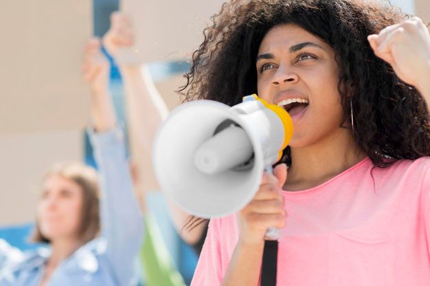 A woman shouting into a megaphone at a protest