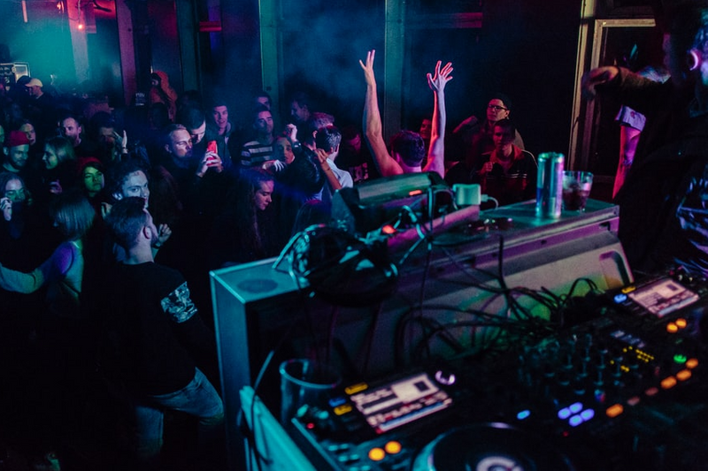 People dancing while DJ plays music in club setting