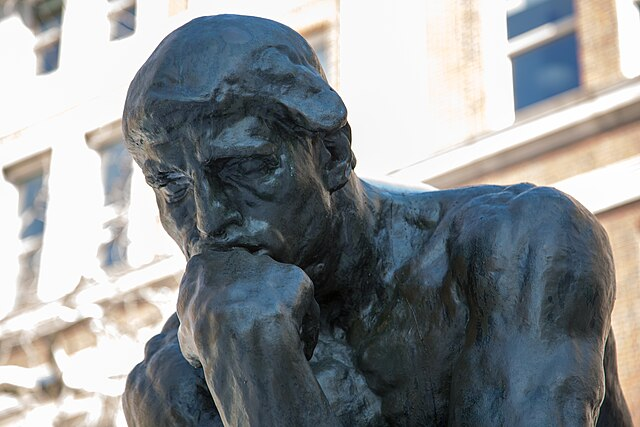 Auguste Rodin's sculpture 'The Thinker', a man seated with his chin resting on his fist, in deep thought