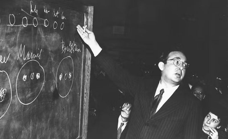 Leo Szilard at  a chalkboard explaining some diagrams.