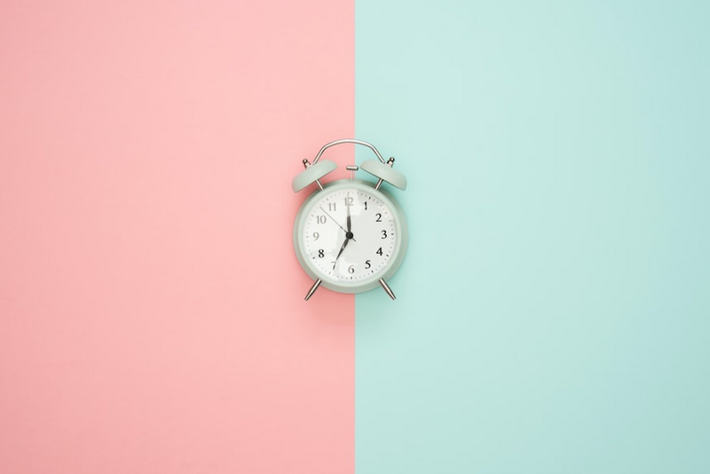 Two tone background with pink on the left side, and seafoam green on the right, with sage green clock timer in the middle