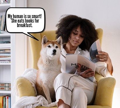 A woman's dog sits on the couch with her as she reads. The dog says, 