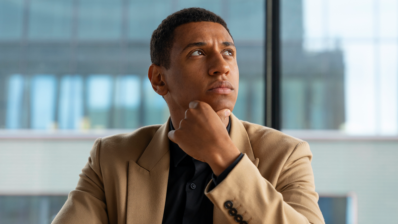 A man at work looking up at the ceiling with a thoughtful expression.