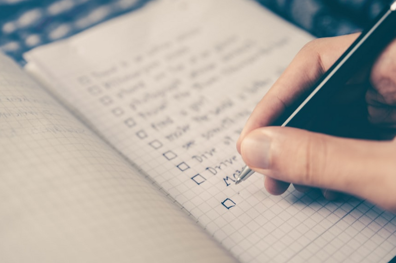 Close up of the right hand of a person writing their to do list