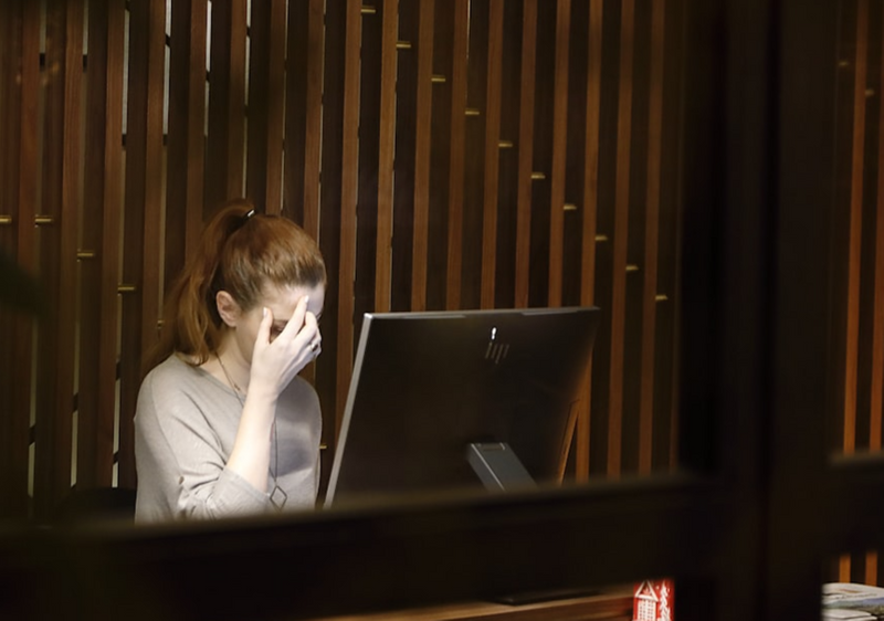 A student looking worried in front of a computer.