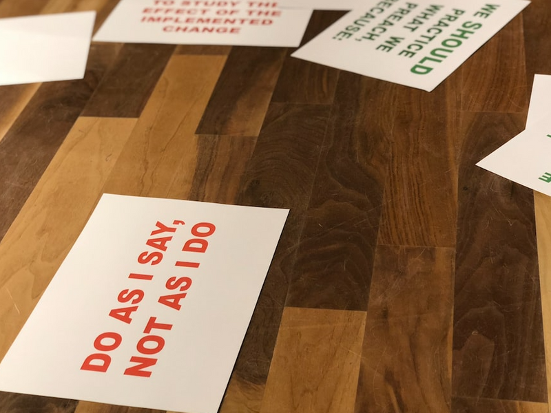An image of cards on a table. One says, 'Do as I say, not as I do' in read font.