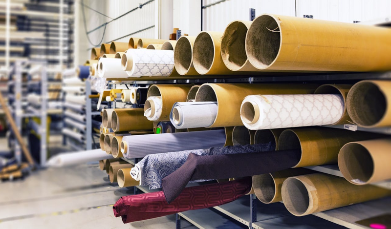 Rolls of fabric on shelves in a fabric store.