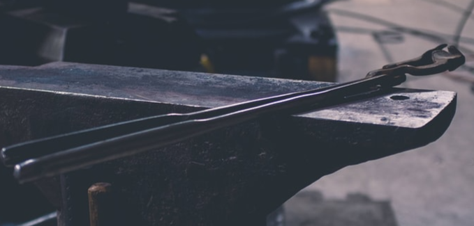 Tongs resting on an anvil.