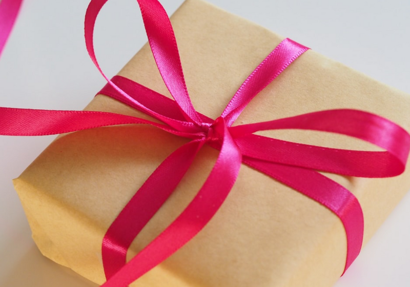 Wrapped present with pink ribbon tied into a bow.
