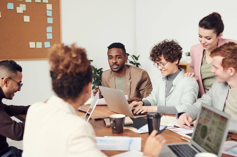 A group of people with a variety of racial backgrounds together in a workplace meeting